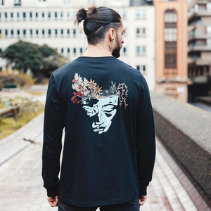 h clothing - male model with back to camera wearing black long sleeved tshirt with graphic of a face and a garden on top of the head