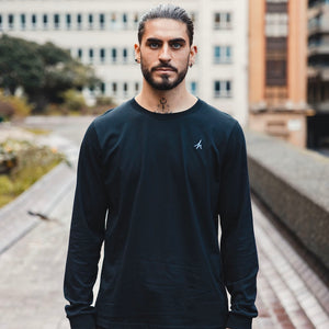 h clothing - male model facing the camera wearing black long sleeved t-shirt with blue h logo on left breast