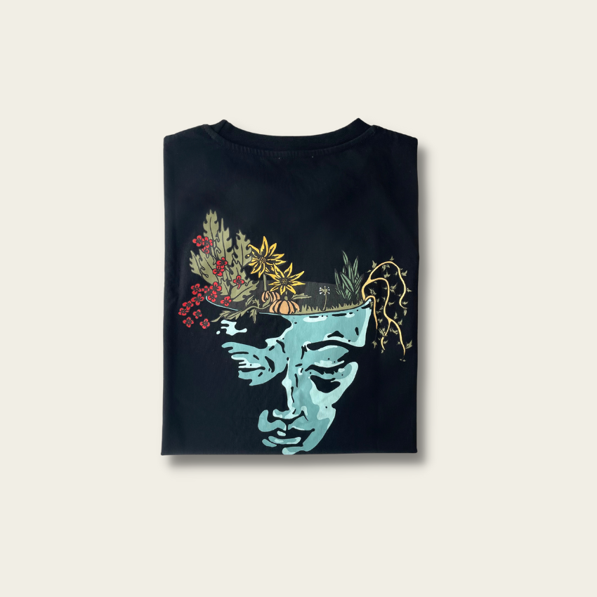 h clothing - flat shot of back of folded black long sleeved tshirt with graphic of a face and a garden on top of the head