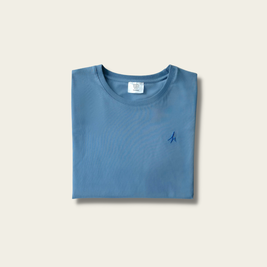 h clothing - flat shot of front of folded blue grey tshirt with blue h logo on left breast