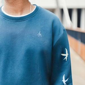 h clothing - close up of male model wearing navy blue sweatshirt with blue h logo on left breast