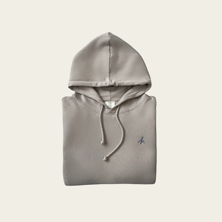 h clothing - flat shot of front of folded heather grey hoodie with blue h logo on left breast