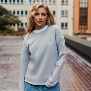 h clothing - female model facing the camera wearing heather grey sweatshirt with colourful birds on left arm