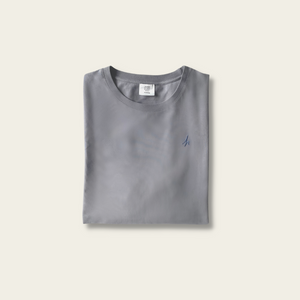 h clothing - flat shot of front of folded pastel grey tshirt with blue h logo on left breast