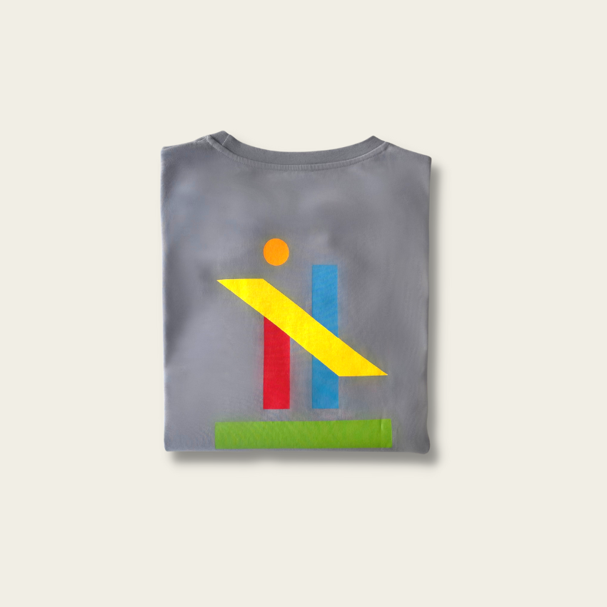 h clothing - flat shot of back of folded pastel grey tshirt with graphic of colourful geometric shapes