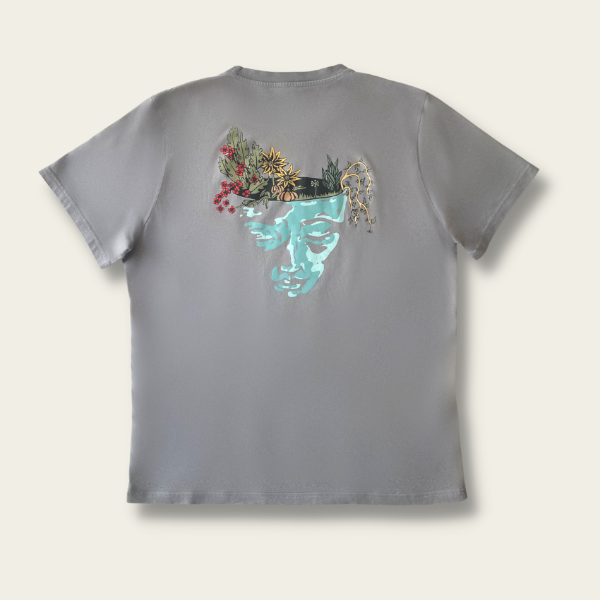 h clothing - flat shot of back of pastel grey tshirt with graphic of a face and a garden on top of the head
