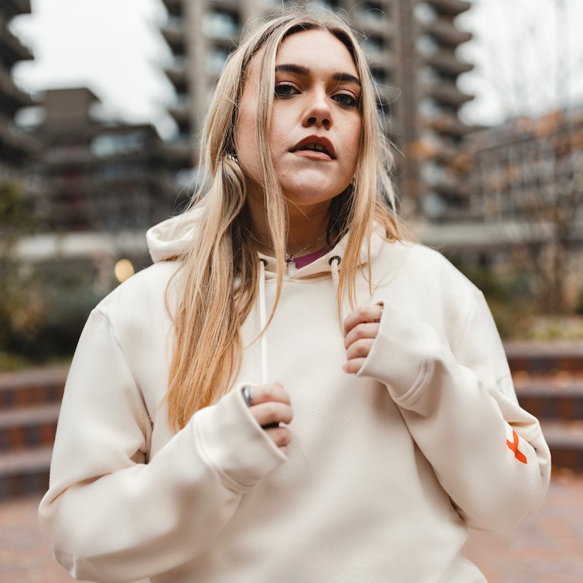 h clothing - close up of female model facing the camera wearing off-white cream hoodie