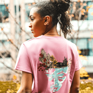h clothing - female model with back to camera wearing pastel pink tshirt with graphic of face and garden design