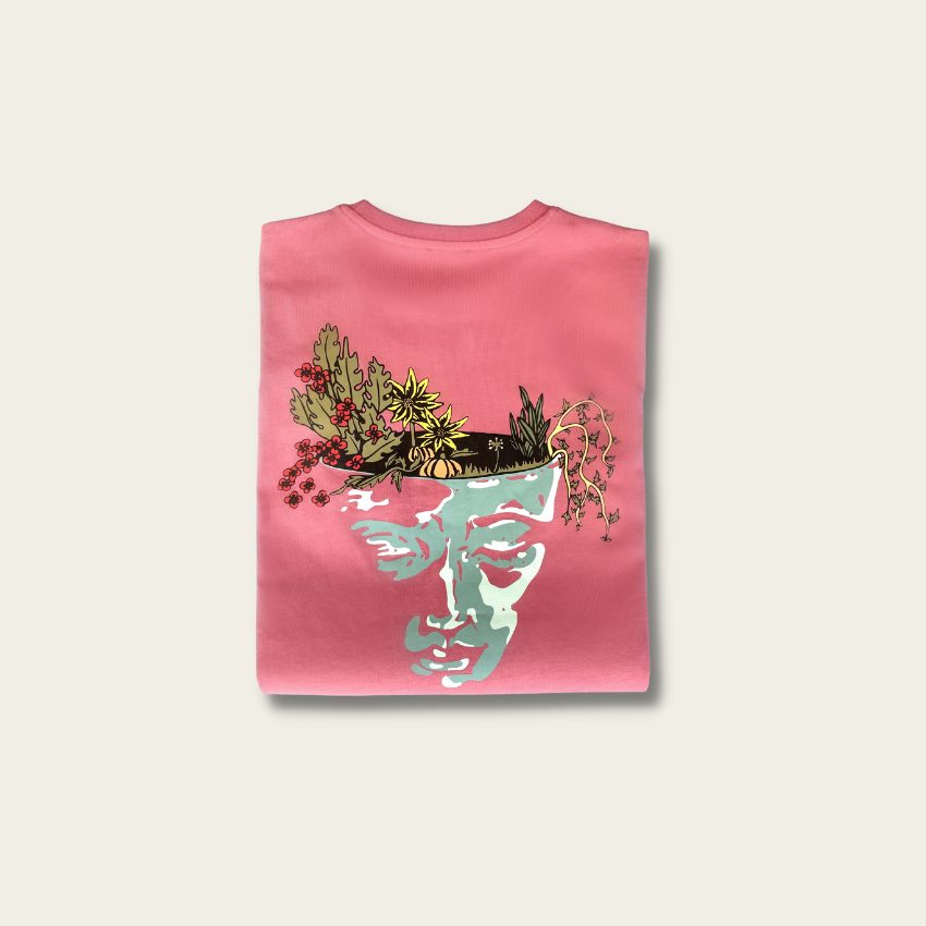 h clothing - flat shot of back of folded rose tshirt with graphic of a face and a garden on top of the head