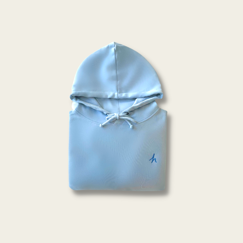 h clothing - flat shot of front of folded sky blue hoodie with blue h logo on left breast