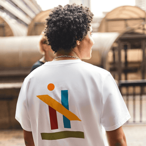 h clothing - male model facing away from camera wearing white tshirt with graphic of colourful geometric shapes